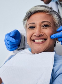 Woman smiling while holding small mirror