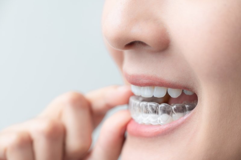 person removing their Invisalign aligners